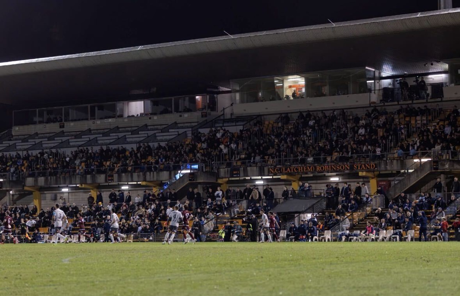 Grandstand crowd at a floodlit night football match